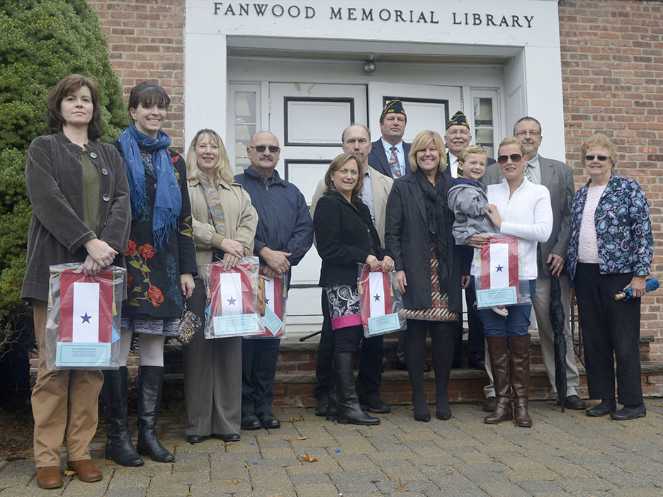 Mayor Colleen Mahr, center, and Council members Kathy Mitchell and Tom Kranz, pose for a photo with VFW and American Legion officials and family members of Fanwood residents now serving in the military during the Veterans' Day ceremony in Fanwood, NJ, Wednesday, Nov. 11, 2015. (Photo by Brian Horton)