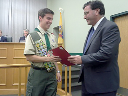 (above, r-l) Mayor Paul Mirabelli handing a copy of the proclamation to Ryan Bonk commemorating his rank as Eagle Scout at Mountainside Borough Hall.